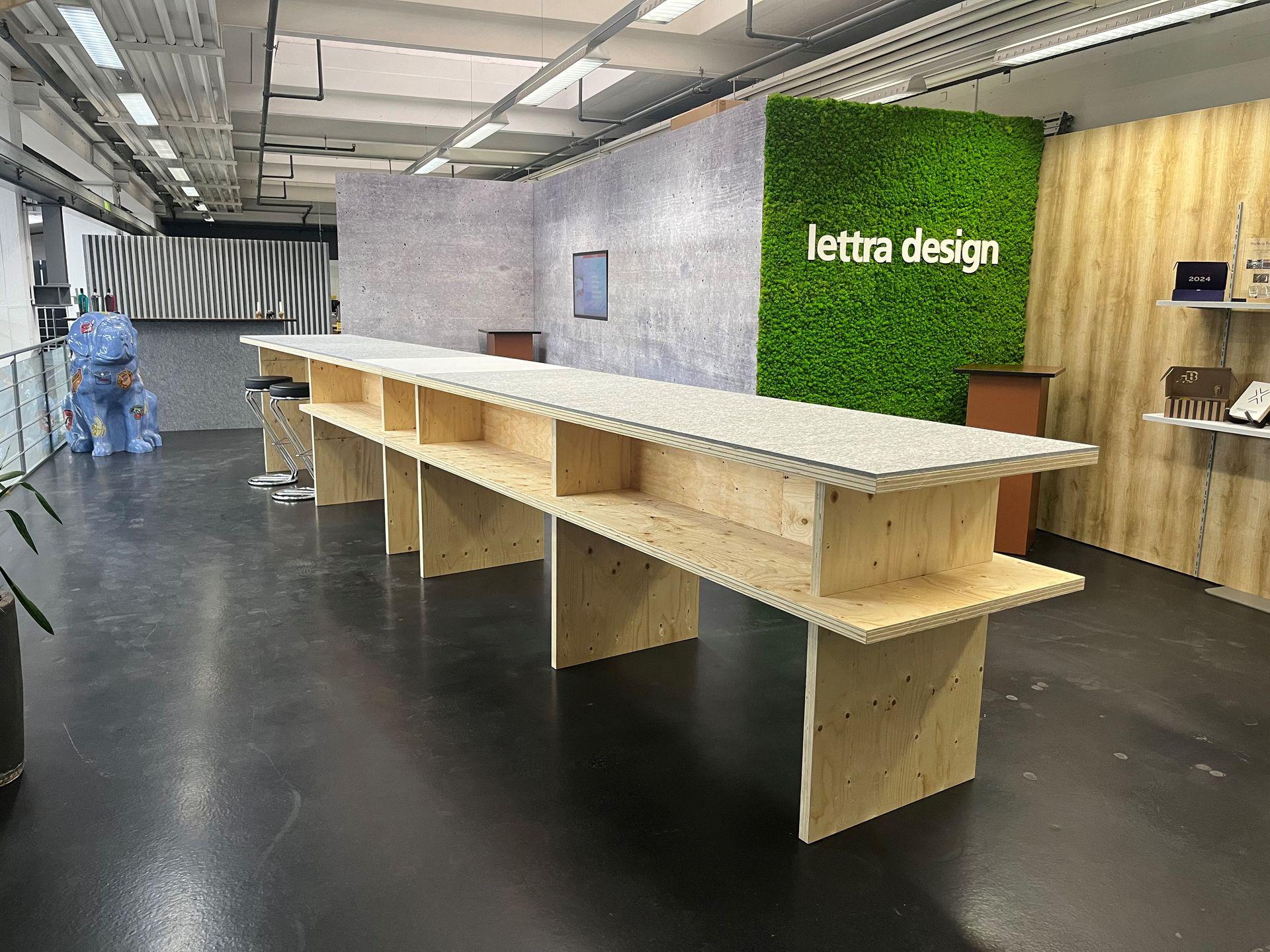 Messestand von Lettra Design mit Mooswand und Holztheke